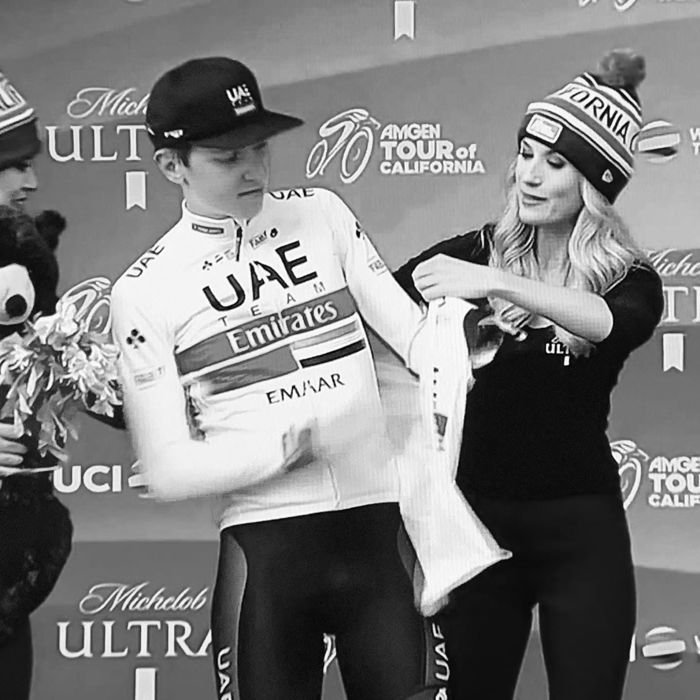UAE Team Emirates rider receiving a leader's jersey on the podium