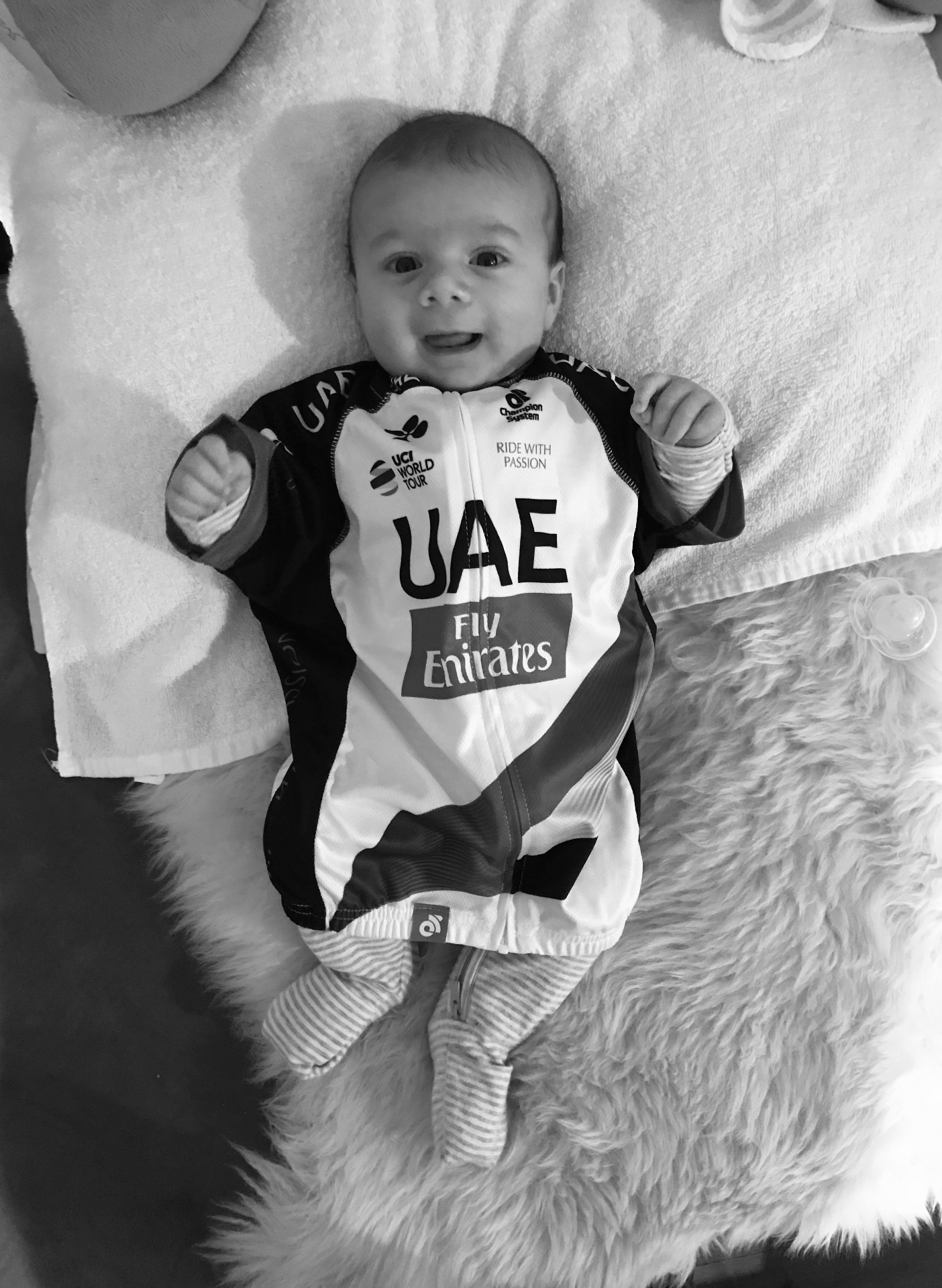 Baby Sebastien wearing a UAE Team Emirates cycling jersey