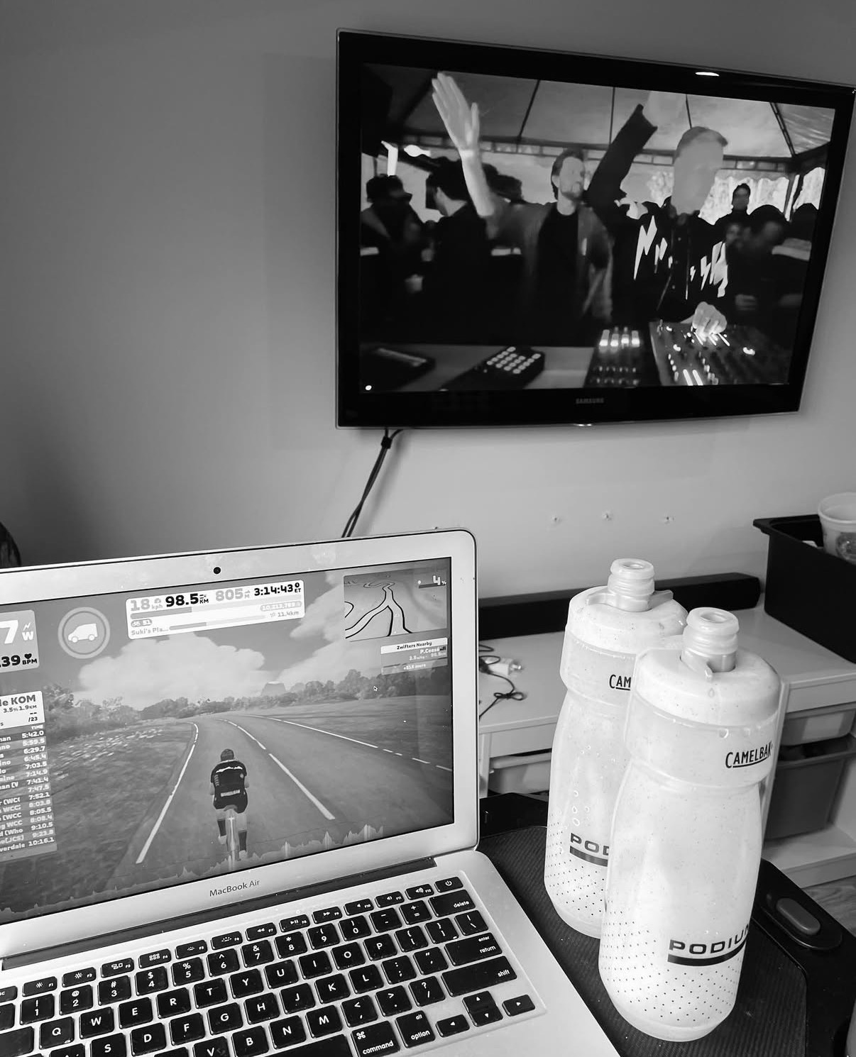 Indoor trainer setup with Zwift on a MacBook and a movie playing on the TV